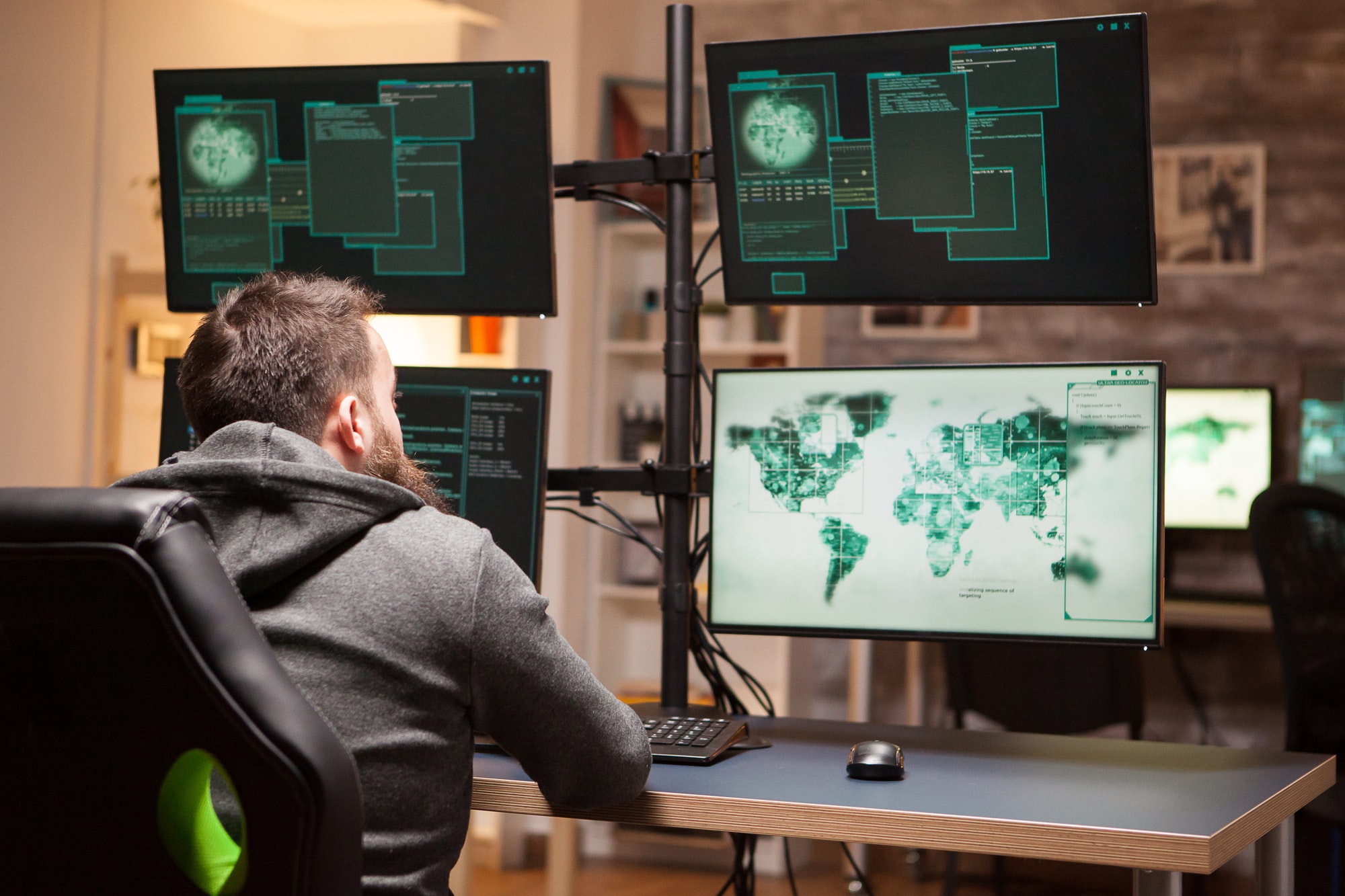 Cybersecurity analyst focused on monitoring global network activity across multiple computer screens, 24/7 Security Monitoring and Threat Detection, Seamless Operations, Optimized Resources, Vulnerability Management and Patching