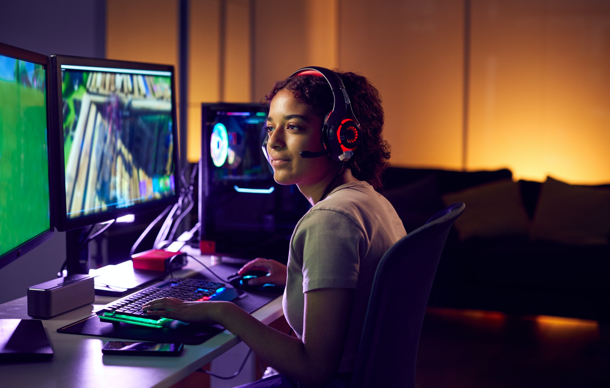 Focused customer support representative with headphones at a computer workstation, ready to assist clients